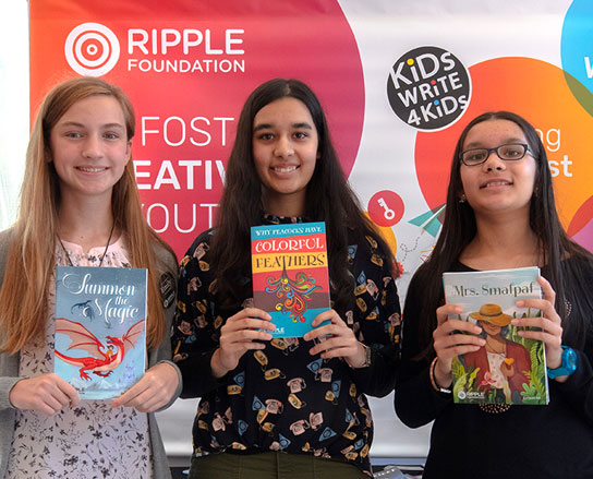 Photograph of 3 girls holding their published winning stories
